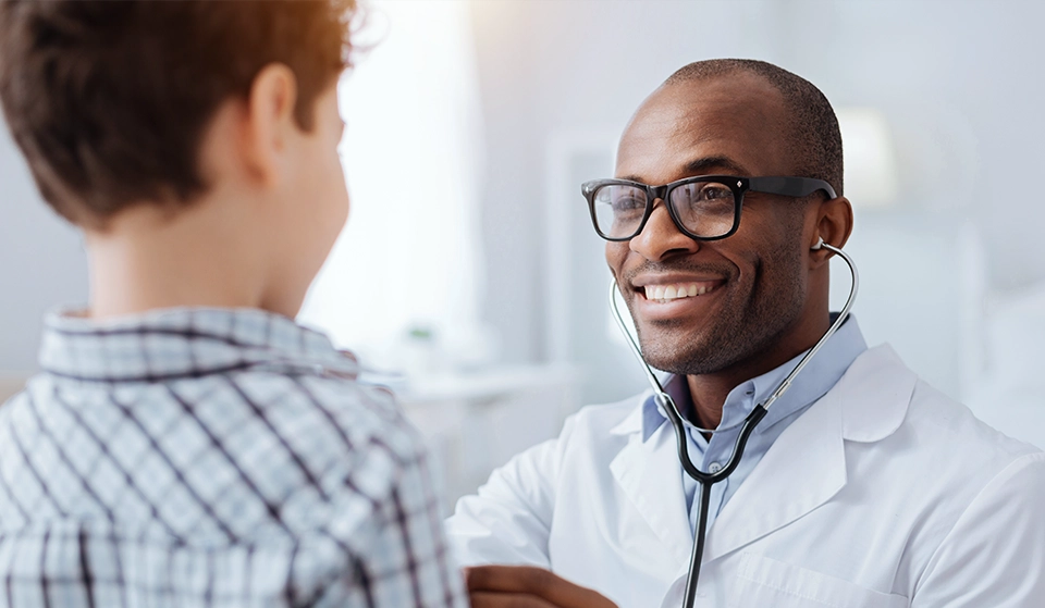 Doctor is smiling well helping a child patient.